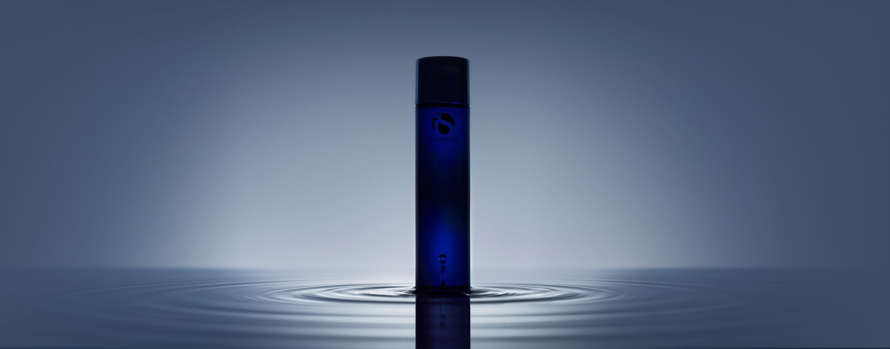 The new iS Clinical cleanser standing in still water, lit from behind