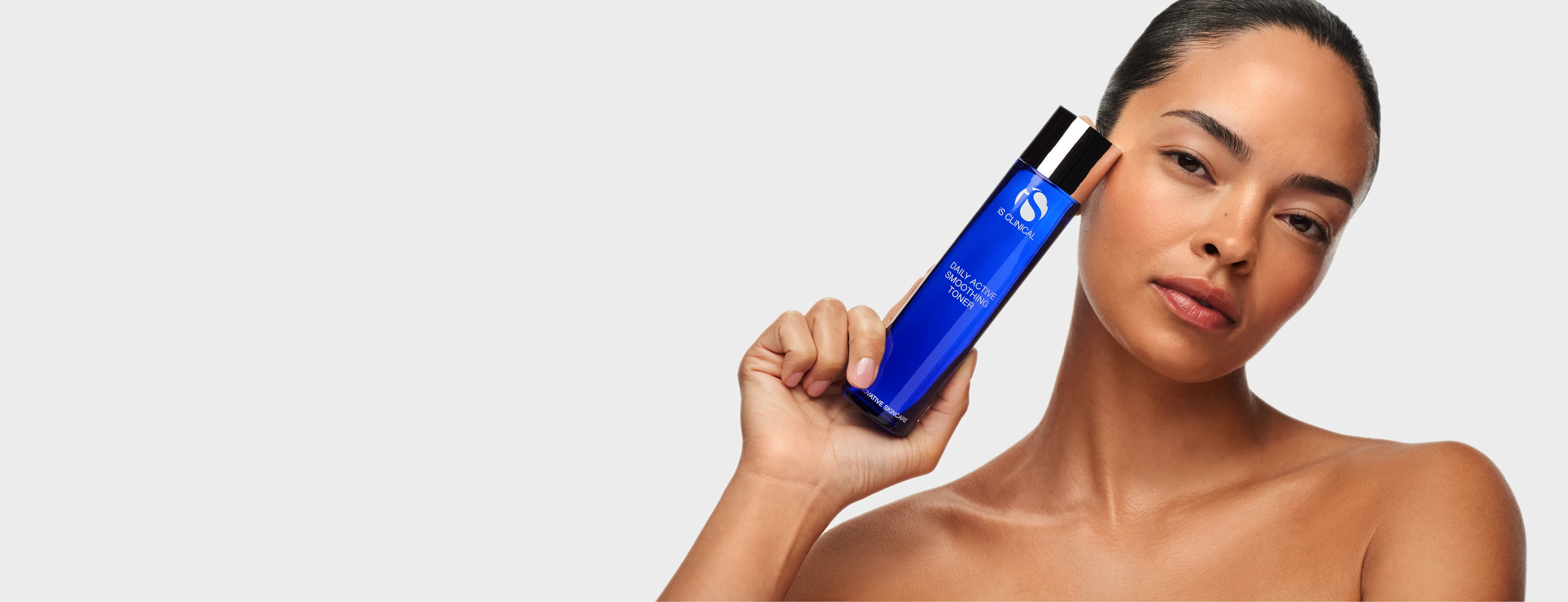 Woman holding iS Clinical Daily Active Smoothing Toner